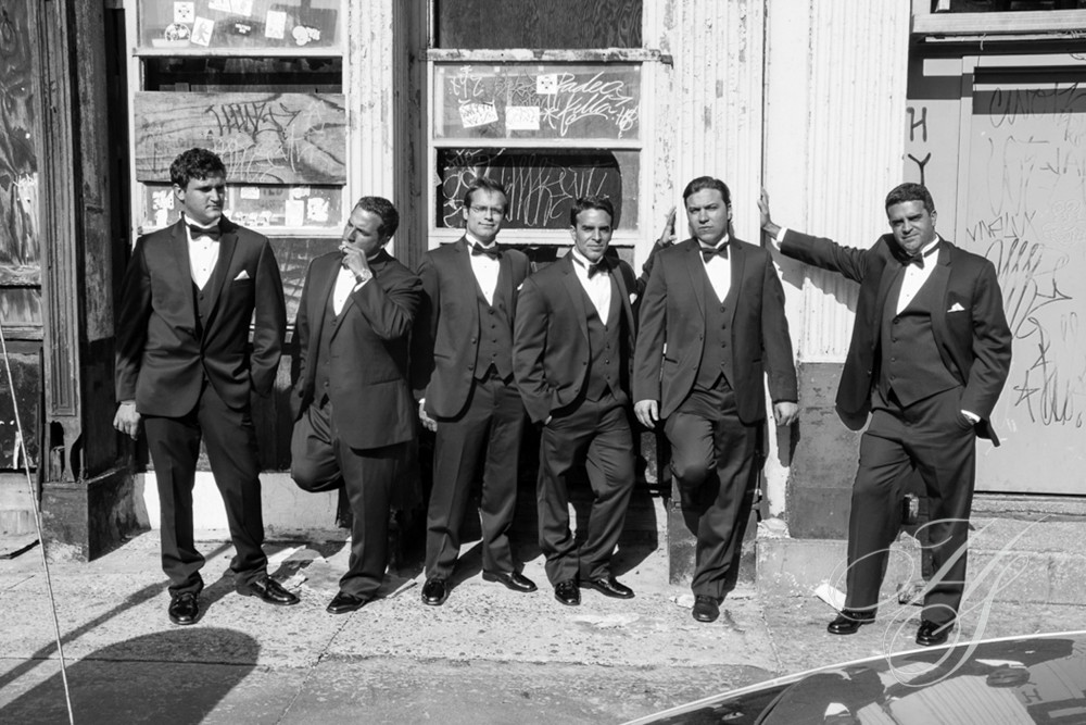 A group of men in suits standing on the side walk