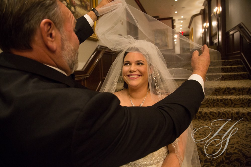 A man taking a picture of a woman in her wedding dress.