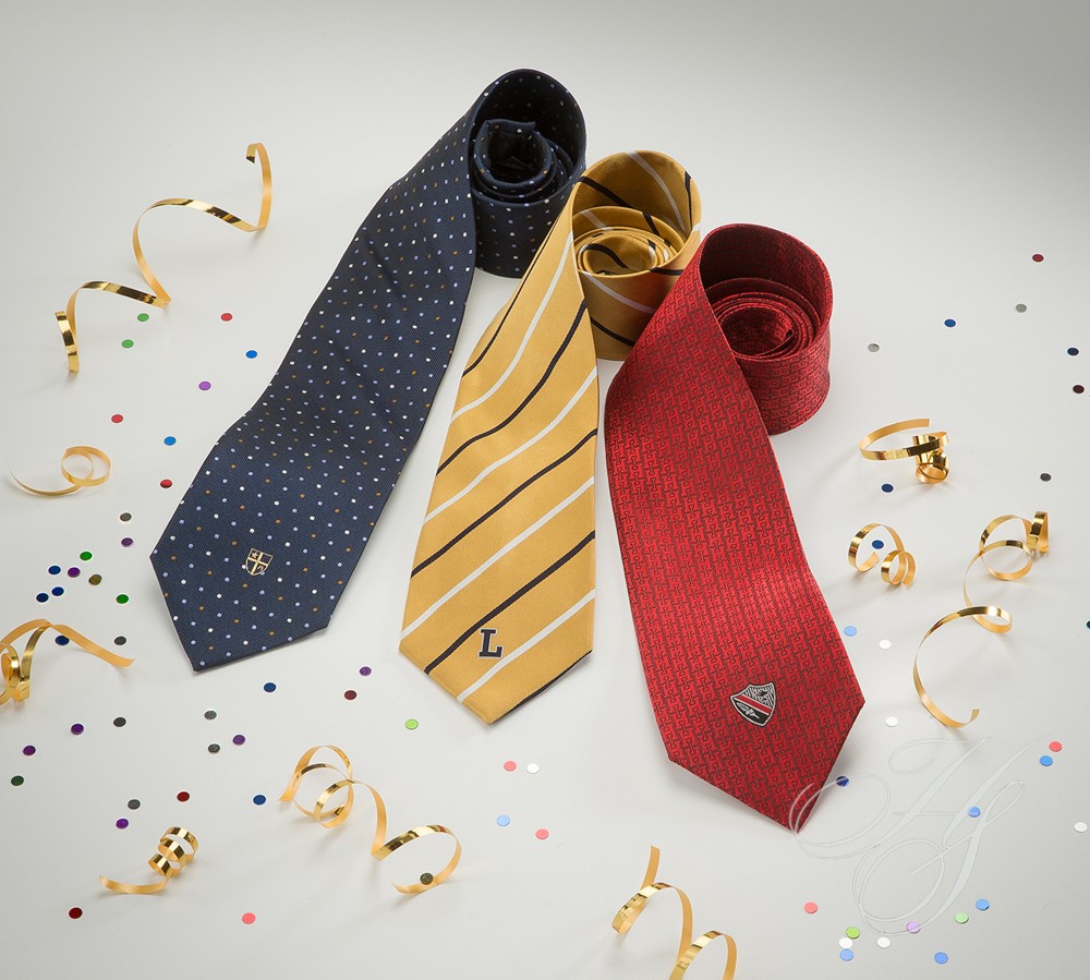 Three ties are laying on a table with confetti.
