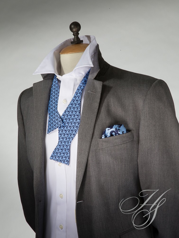 A suit and tie with a blue bow tie.
