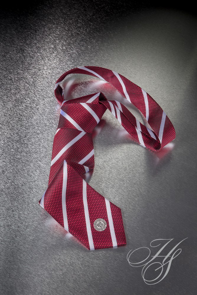 A red and white striped tie with a logo on it.
