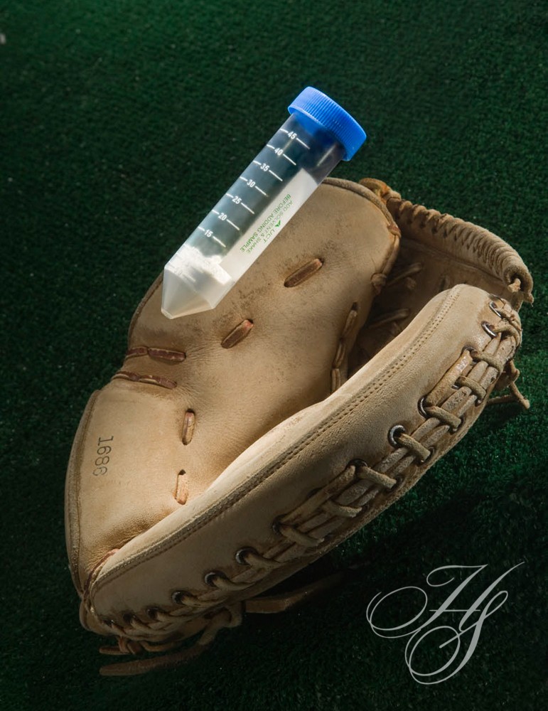 A baseball glove with a bottle in it.