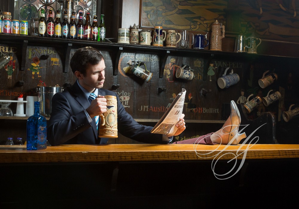 A man sitting at the bar reading a newspaper.