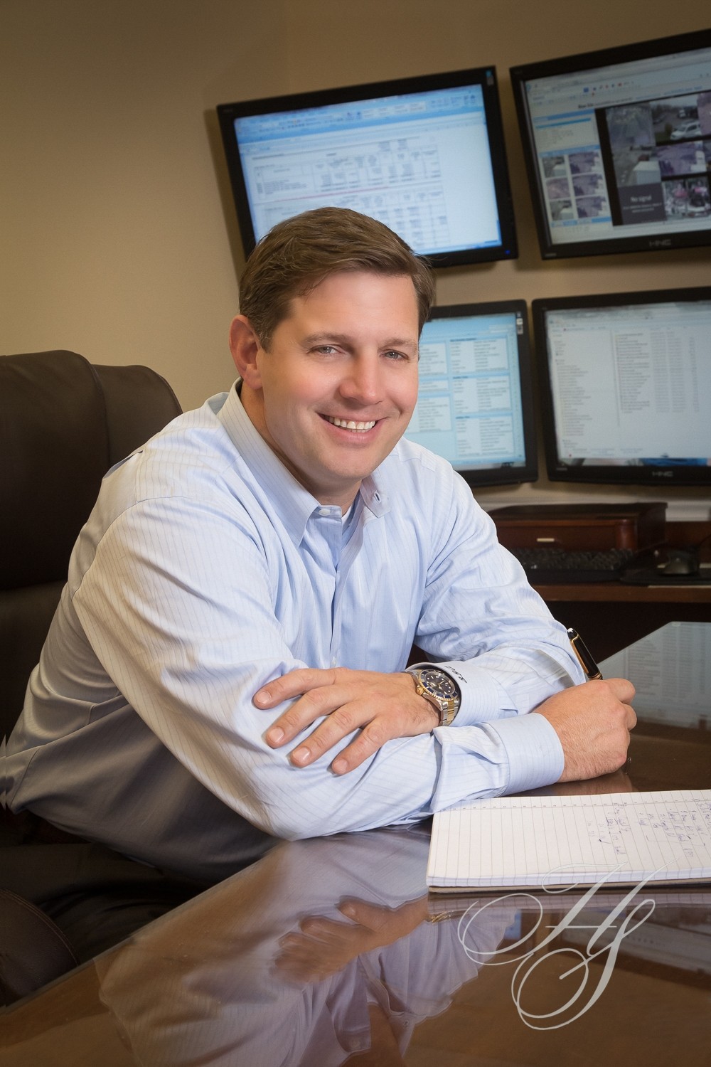 A man sitting in front of computer monitors.