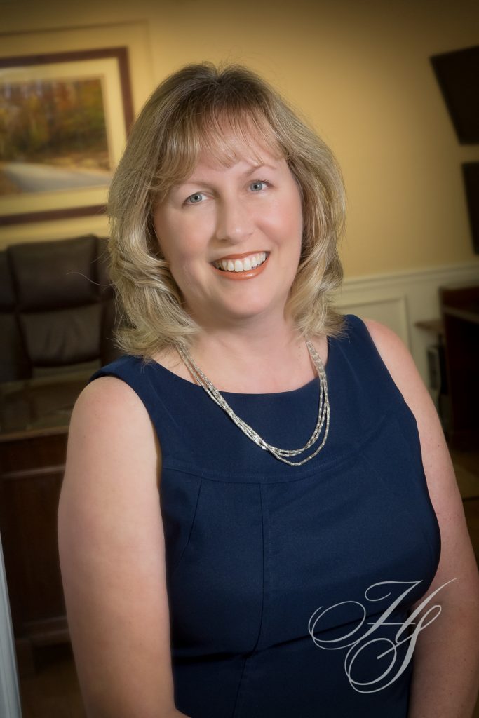 A woman in a blue dress smiling for the camera.