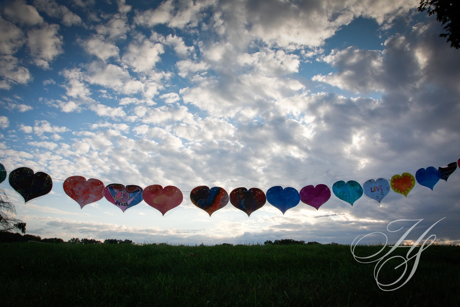 A line of hearts are flying in the sky.