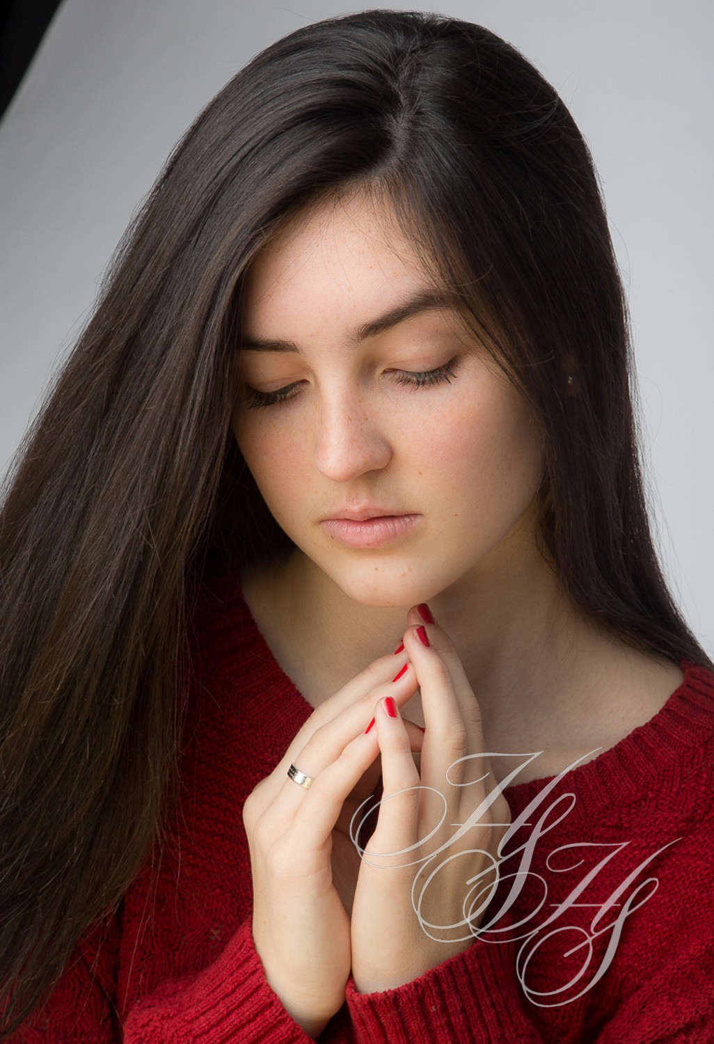 A woman with long hair is touching her face.
