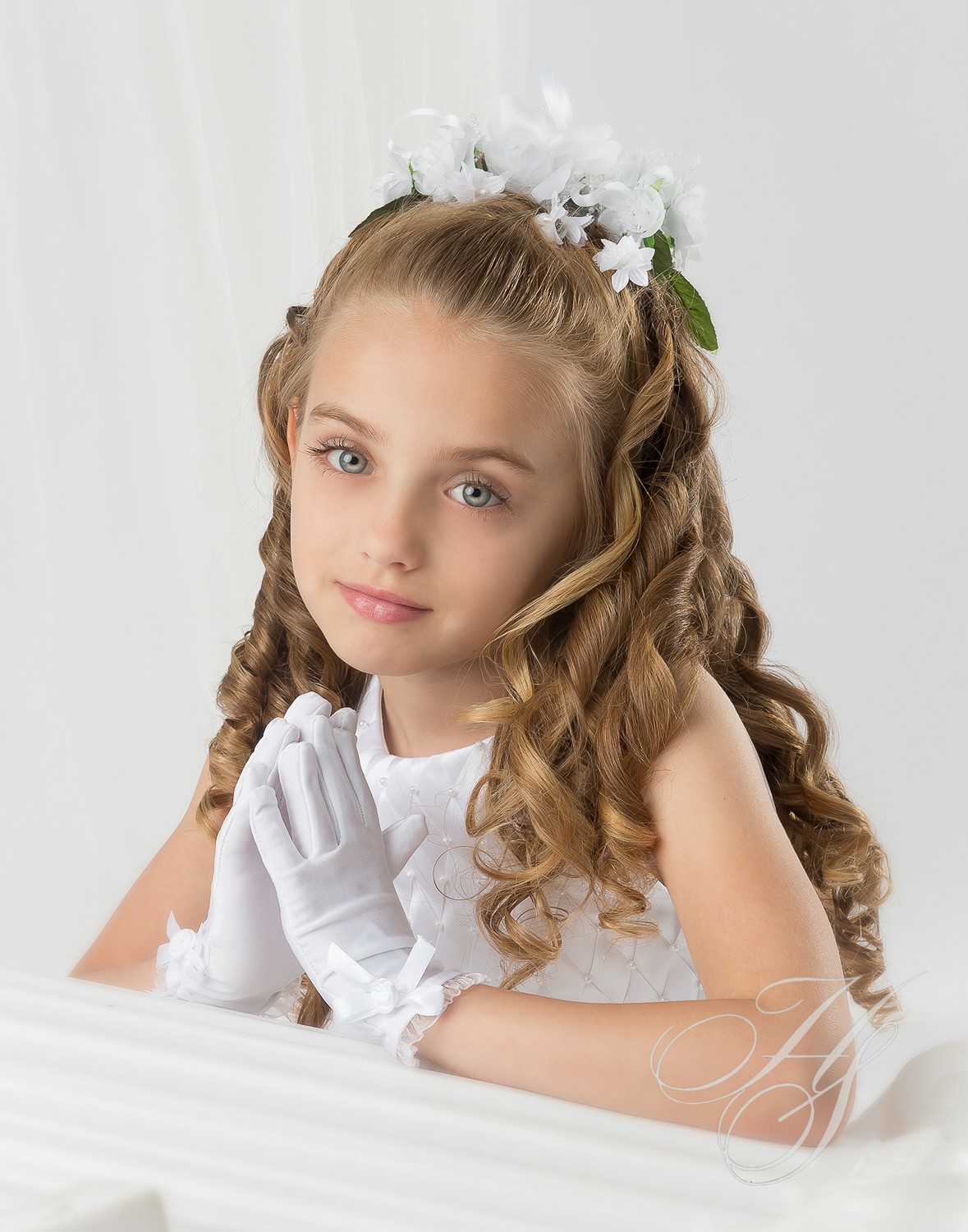 A little girl with long hair and flowers in her hair.