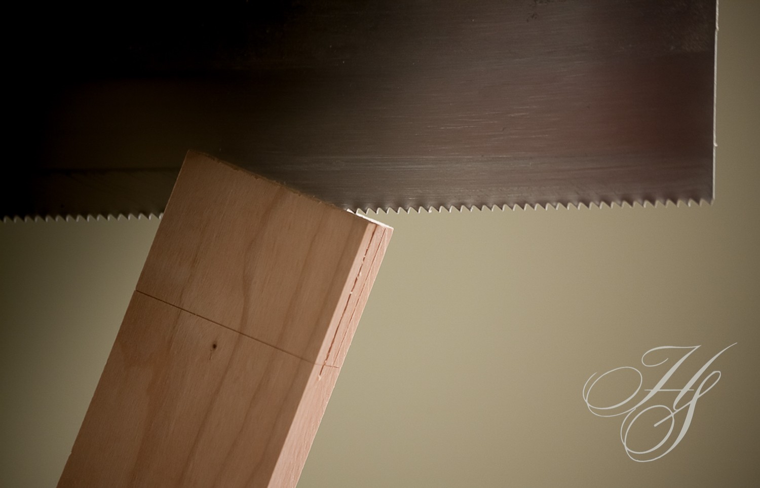 A close up of a wood board and a saw blade