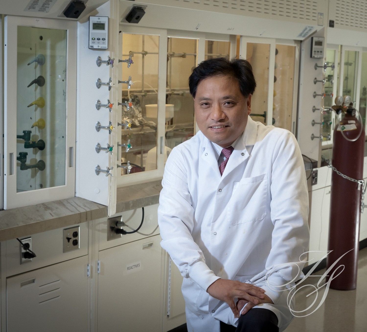 A man in white lab coat standing next to glasses.