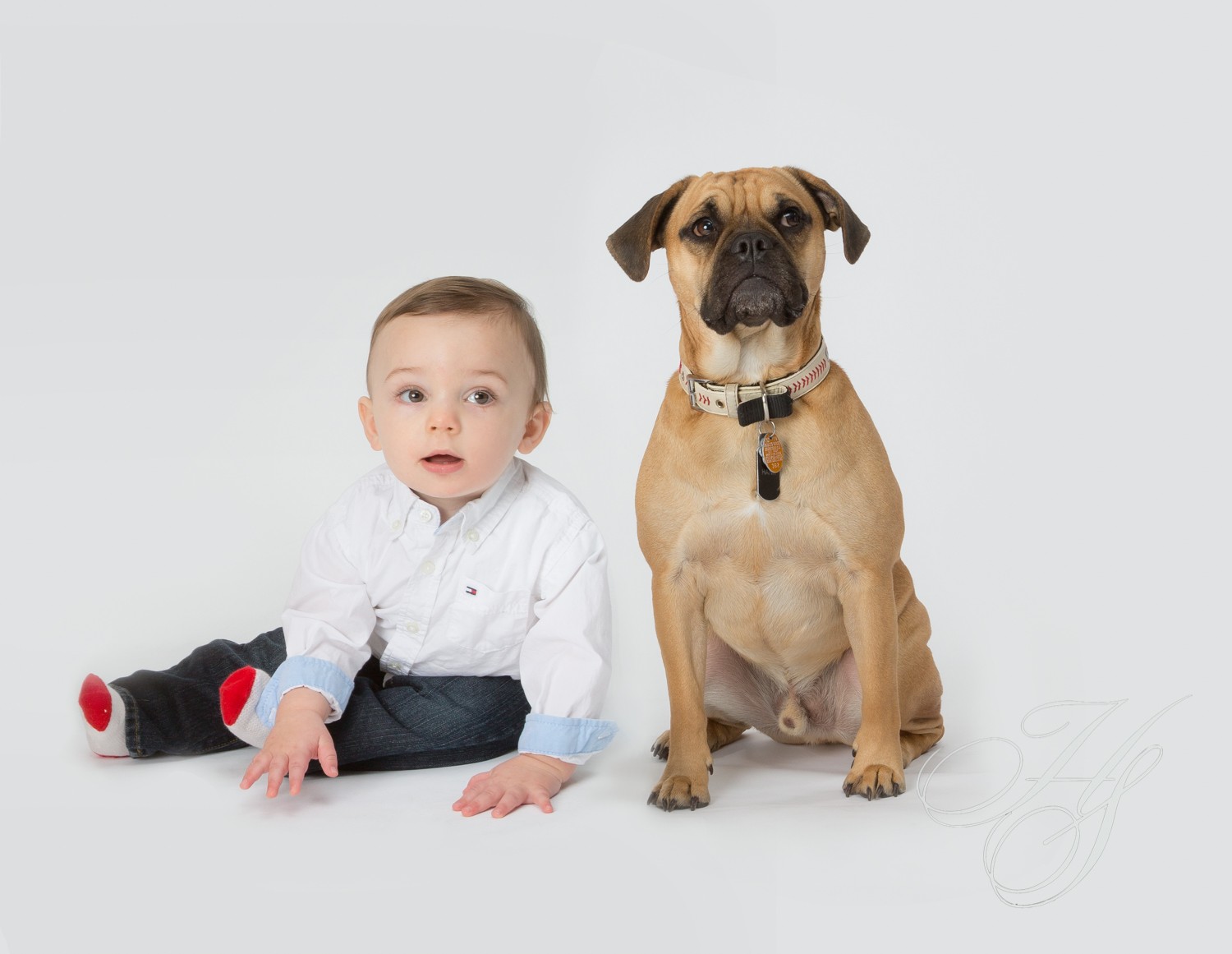 A baby and dog sitting next to each other.