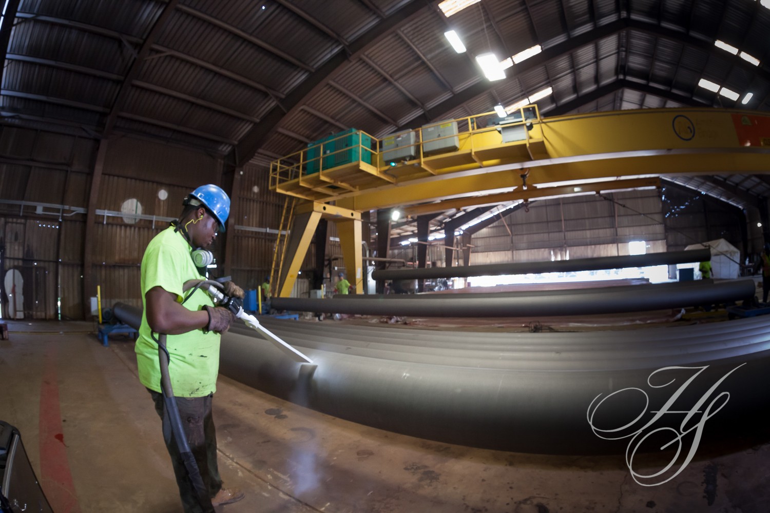 A man in an industrial setting with a crane.