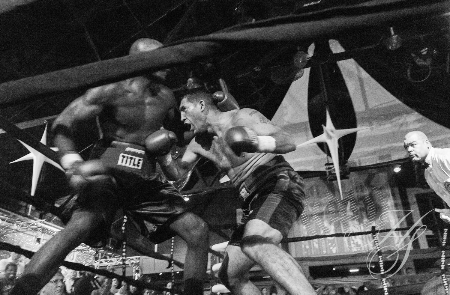 Two boxers are fighting in a boxing ring.
