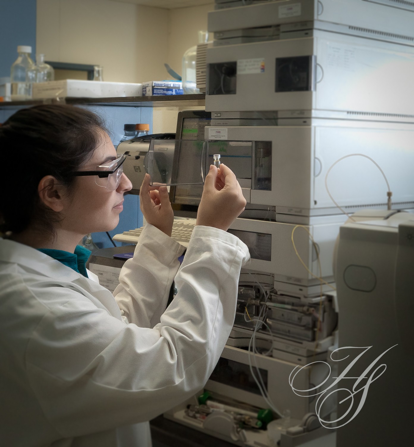 A woman in lab coat holding up something to look at.