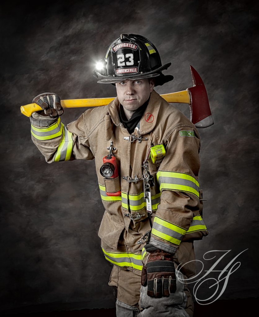 A fireman holding an axe and wearing a helmet.