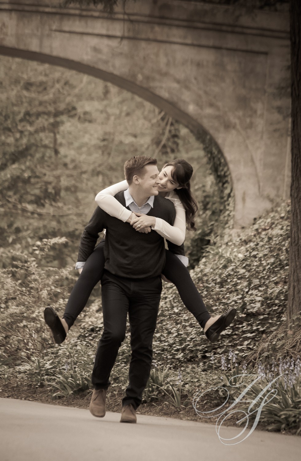 A man and woman are hugging in the woods.