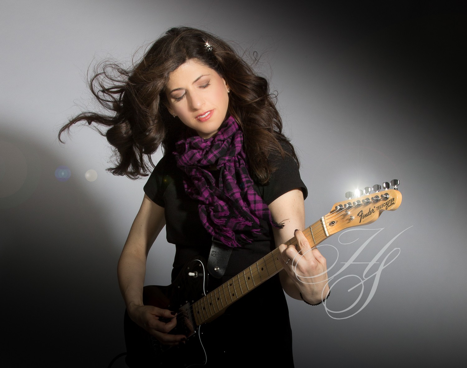 A woman holding a guitar in her hand.