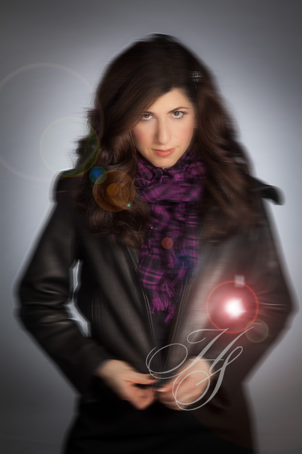 A woman in black jacket holding a red object.