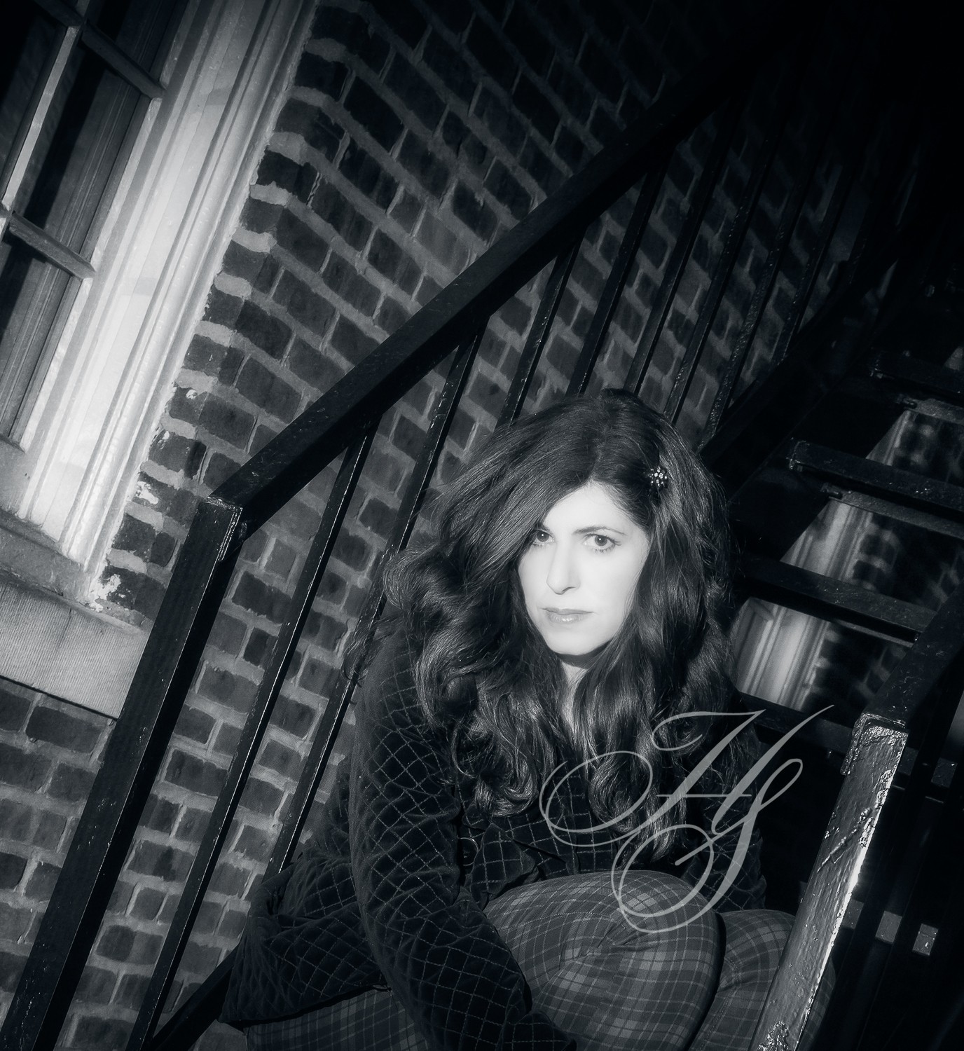 A woman sitting on top of stairs in front of a window.