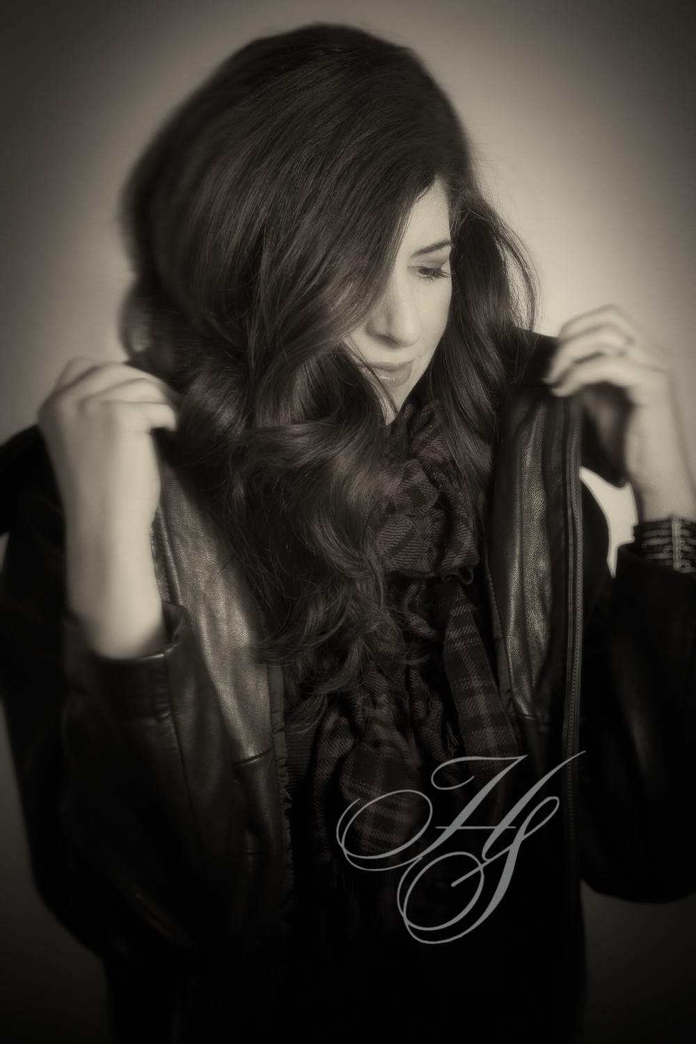 A woman with long hair is holding her coat over her shoulder.