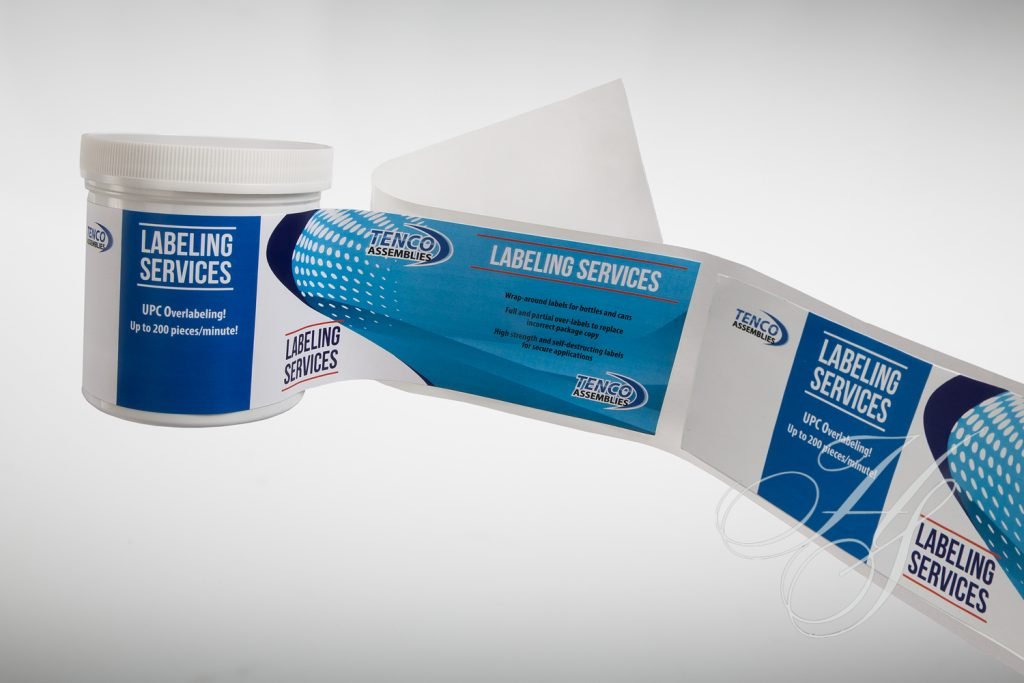 A white and blue business card sitting next to a container.