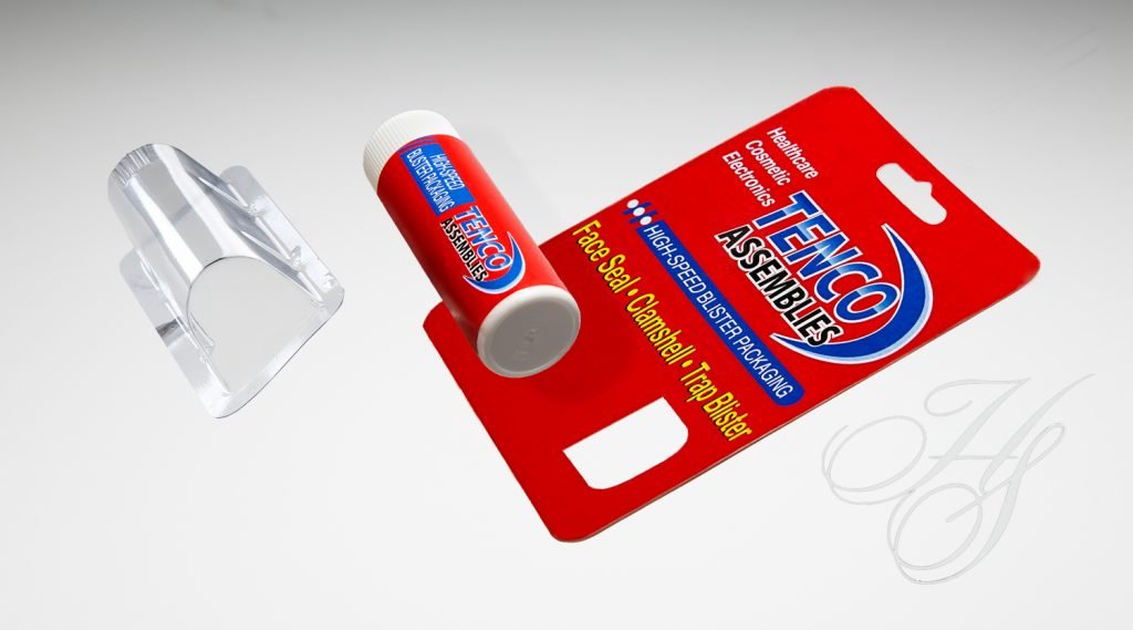 A red and white tube of toothpaste on top of a card.
