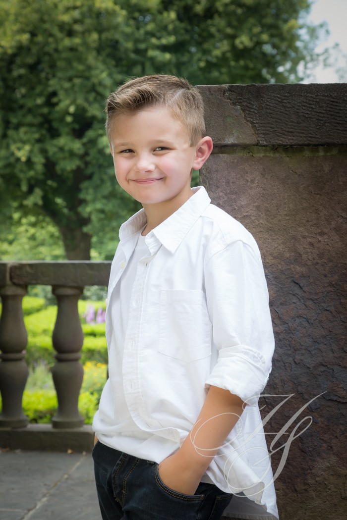 A young boy in white shirt and shorts.
