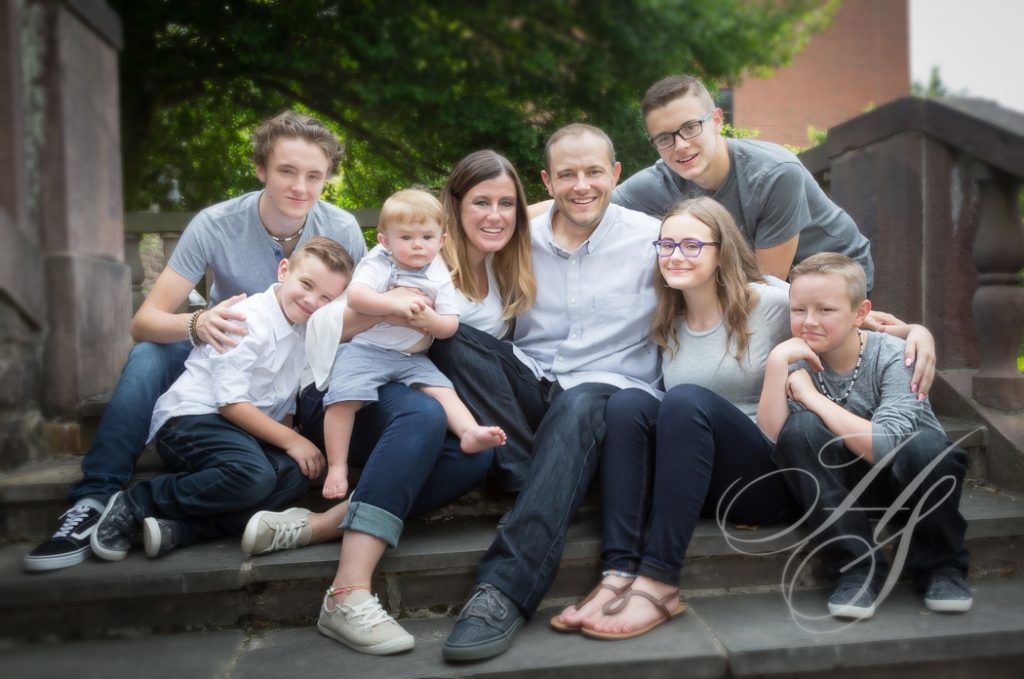 A group of people sitting on steps with one man holding a baby.