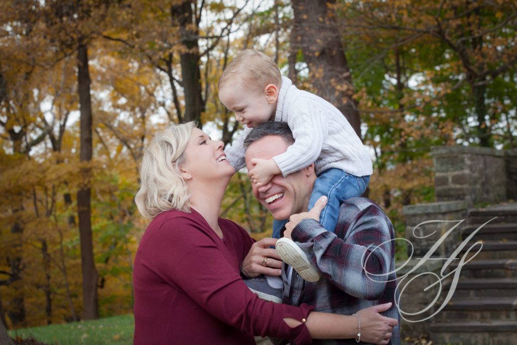 A family is posing for the camera in front of trees.