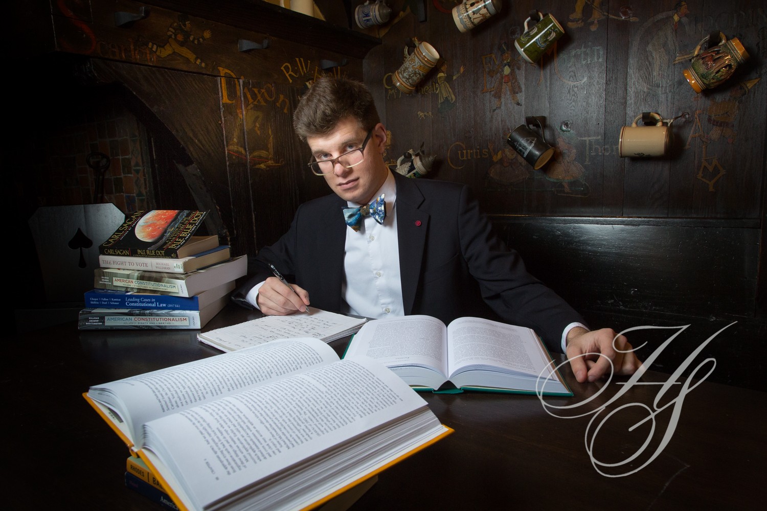 A man sitting at a table with several books.