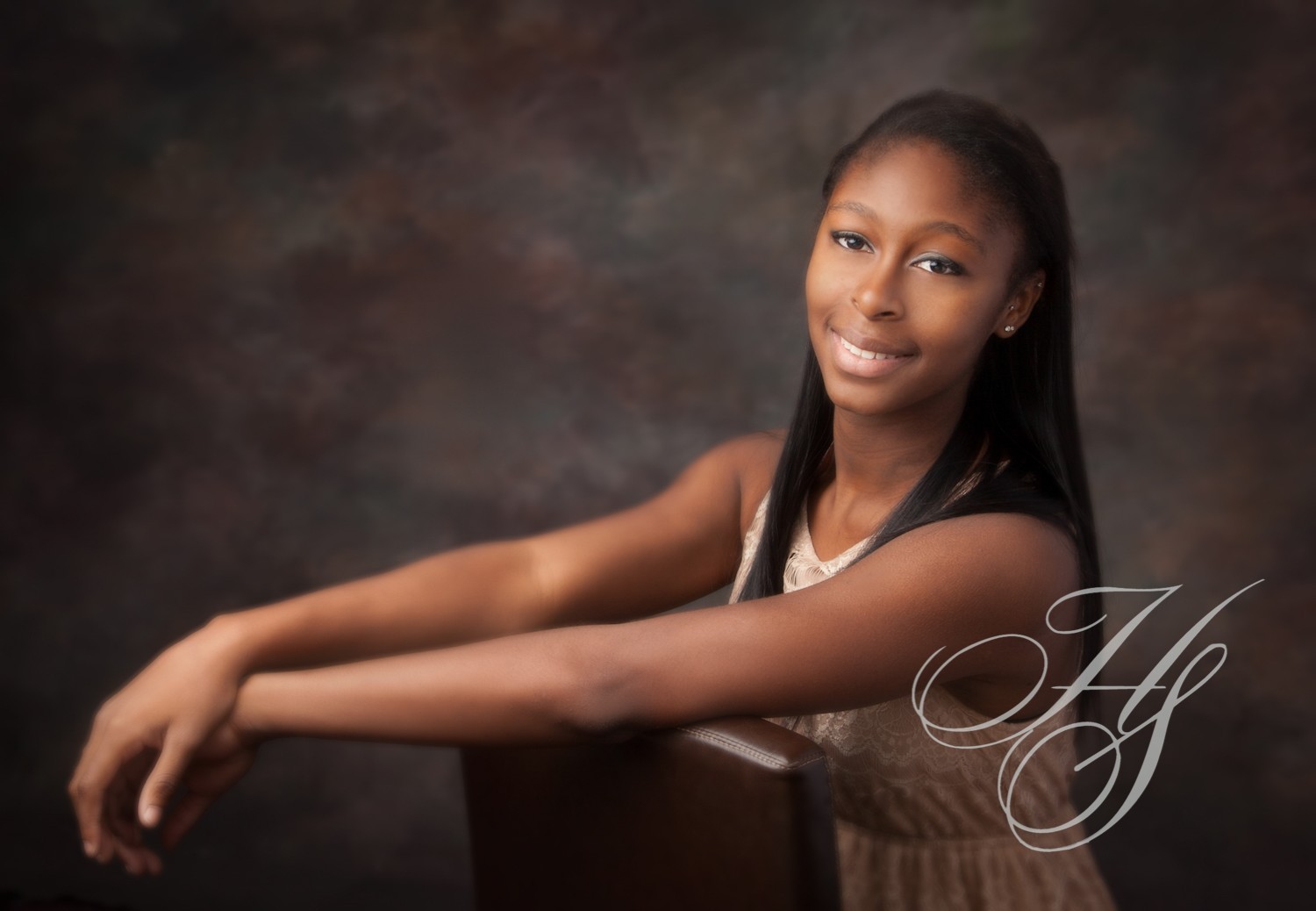 A young woman posing for a picture in front of a dark background.