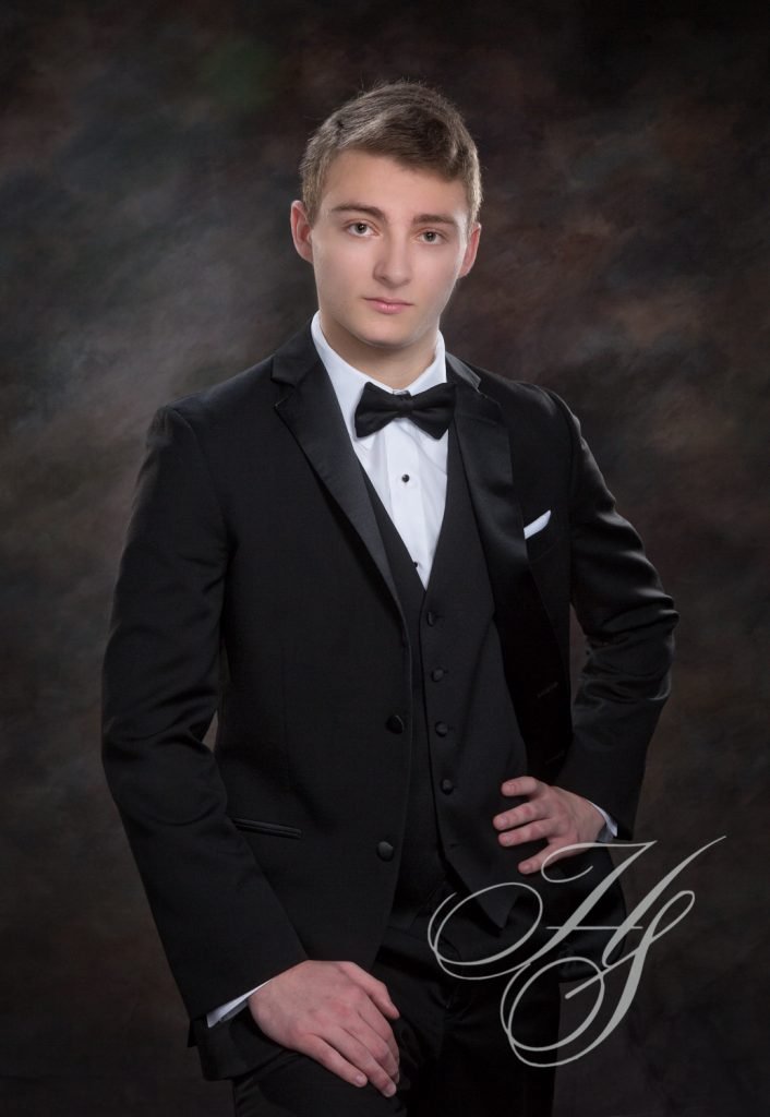 A man in a tuxedo posing for the camera.