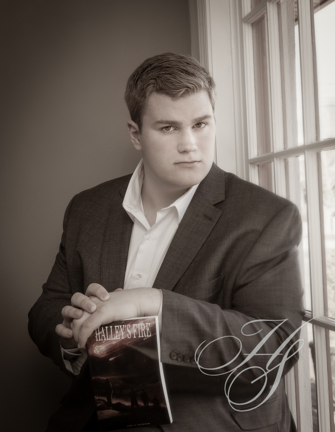 A man in suit and tie leaning against the wall