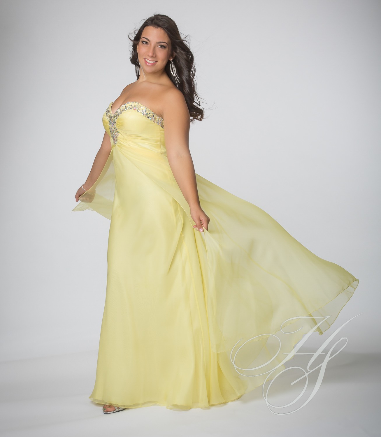 A woman in a yellow dress posing for the camera.