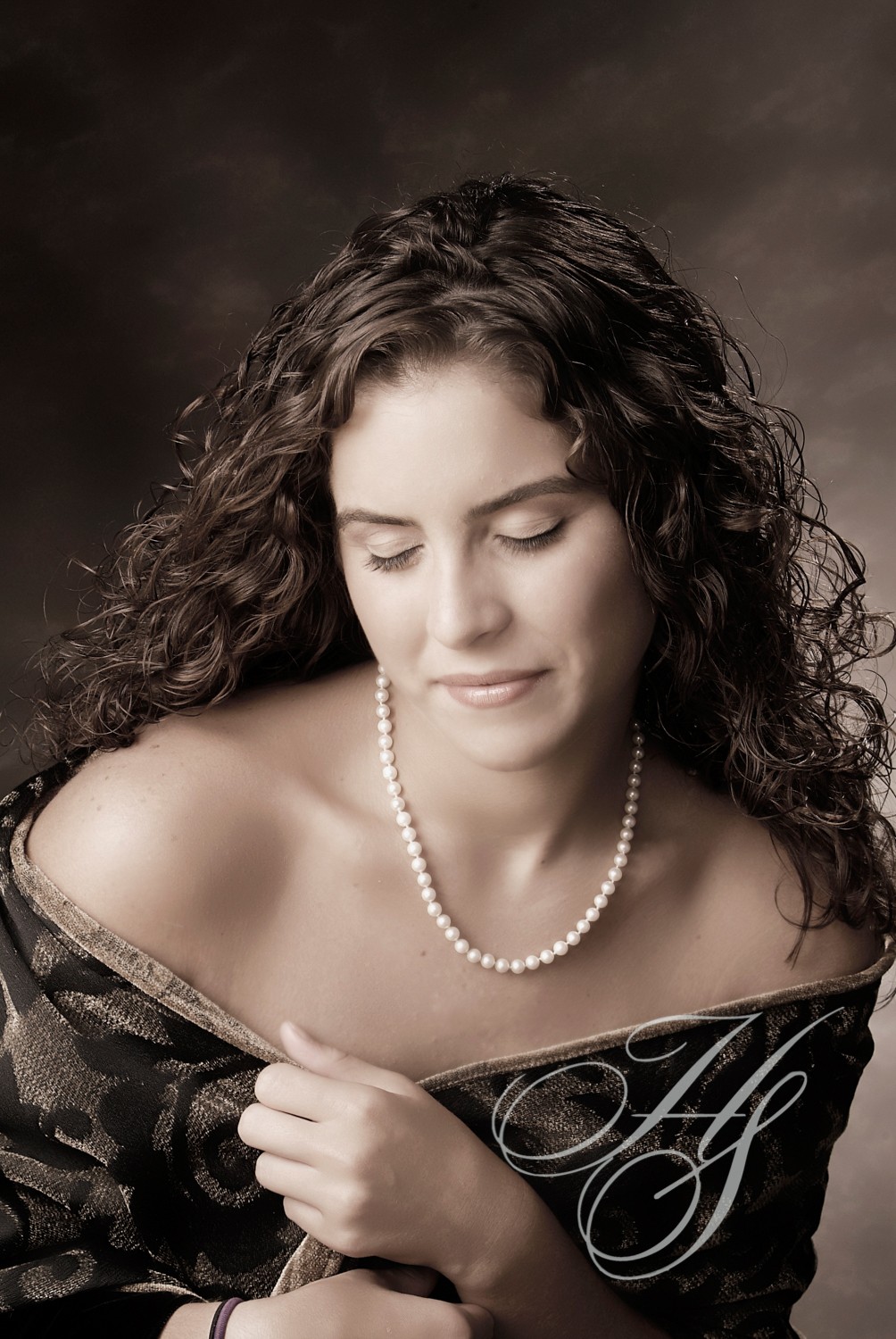 A woman with long hair and pearls in her hair.