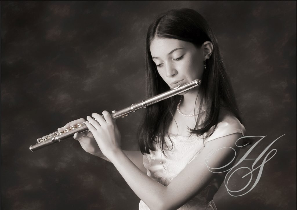 A woman is playing the flute in black and white.