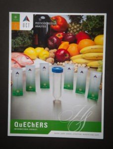 A poster of various fruits and vegetables with a bottle.