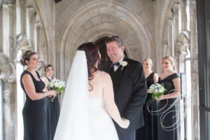 A bride and groom are smiling at each other.