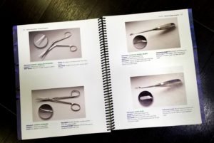 A book with several pages of scissors and other items.